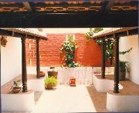 A small 'chettinad' type of courtyard on the first floor of the Dr. Ramamuthi house in Chennai. Traditional wooden pillars and a cement 'thinnai' or seat with the Mangalore tiled roof give it the right ambience.